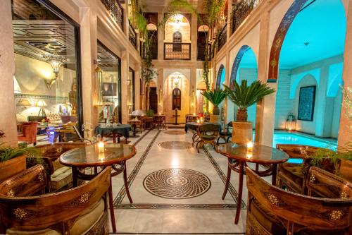 a lobby with tables and chairs and a pool at Dar Anika in Marrakesh