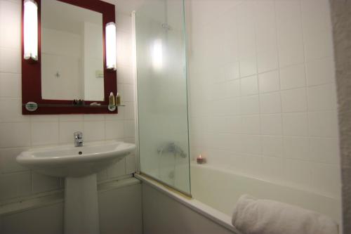 ヴァル・トランスにあるOlympiades Appartements VTIのバスルーム(シンク、鏡付きシャワー付)