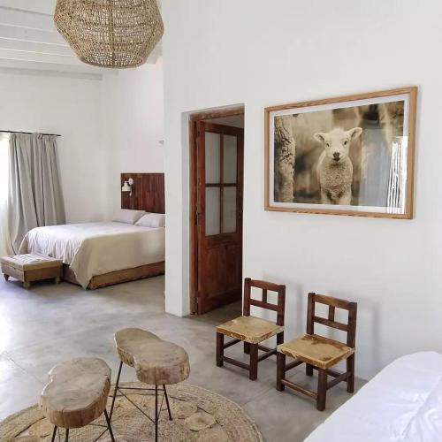 a bedroom with a bed and a picture of a sheep at LA FLORIDA - CASA PUEBLO in San Antonio de Areco