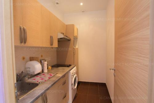 une cuisine avec un évier et une machine à laver dans l'établissement Madeleine, à Cannes