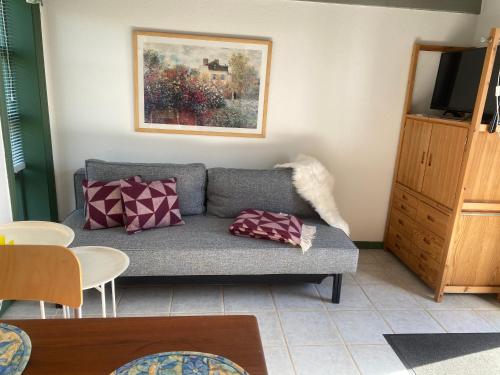 ein Wohnzimmer mit einem Sofa und einem Gemälde an der Wand in der Unterkunft Hyggeligt ved Ejerslev Havn in Ejerslev