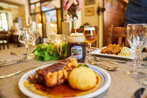 una mesa con un plato de comida y un vaso de cerveza en Sperber Bräu - 3-Sterne-Superior Hotel mit Gasthof und eigener Brauerei - kein Ruhetag en Sulzbach-Rosenberg