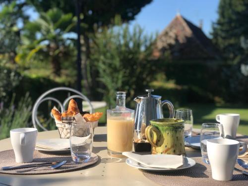 einen Tisch mit einem Frühstück mit Brot und Milch in der Unterkunft Domaine du Manoir in Les Avenières