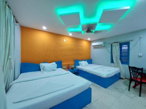 マンダーマニにあるMegha Beach Resort - Sea Viewの緑の天井が特徴のホテルルームで、ベッド2台が備わります。