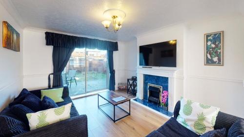 a living room with a couch and a fireplace at Orpington North Townhouse in Orpington