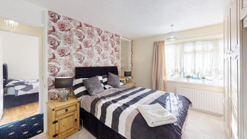 a bedroom with a bed and a large window at Orpington North Townhouse in Orpington