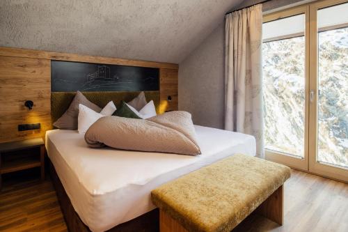 une chambre avec un lit avec des draps blancs et une fenêtre dans l'établissement Die Reblaus, à Ladis
