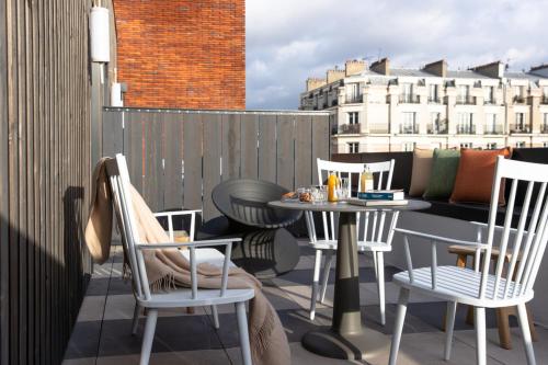 a patio with a table and chairs on a balcony at MOB House in Saint-Ouen