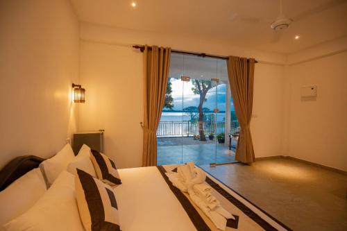 a bedroom with a bed and a view of the ocean at Olu villa Resort in Tissamaharama