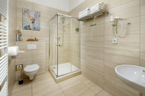a bathroom with a shower and a toilet and a sink at Unesco Prague Apartments in Prague