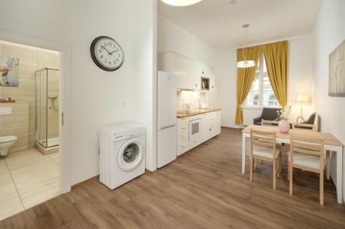 a kitchen and dining room with a table and a clock at Unesco Prague Apartments in Prague