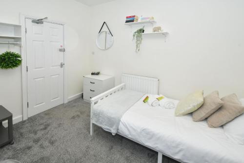 a white bedroom with a bed and a dresser at Townhouse @ Hall O Shaw Street Crewe in Crewe