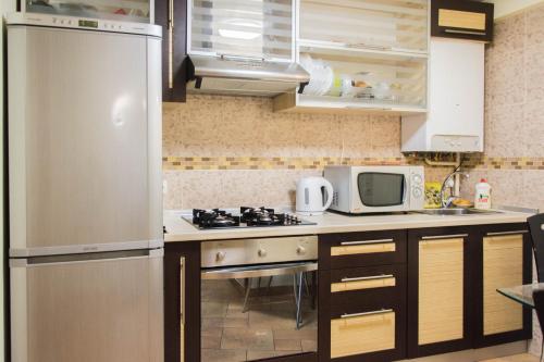 een keuken met een roestvrijstalen koelkast en een magnetron bij Deribasovskaya,16 in Odessa