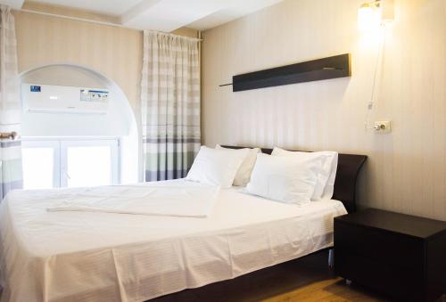 een bed met witte lakens en kussens in een kamer bij Deribasovskaya,16 in Odessa
