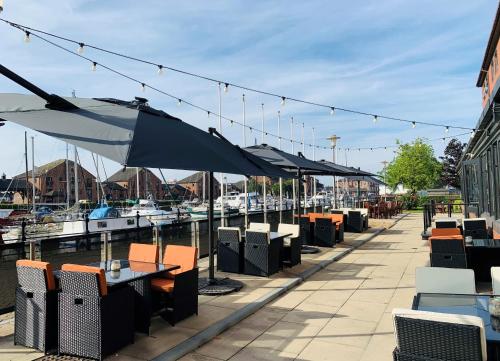 a row of tables and umbrellas at a marina at Holiday Inn Hull Marina by IHG in Hull