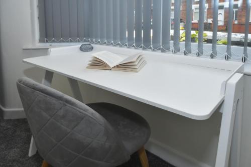 a white desk with an open book and a chair at Townhouse @ Hall O Shaw Street Crewe in Crewe