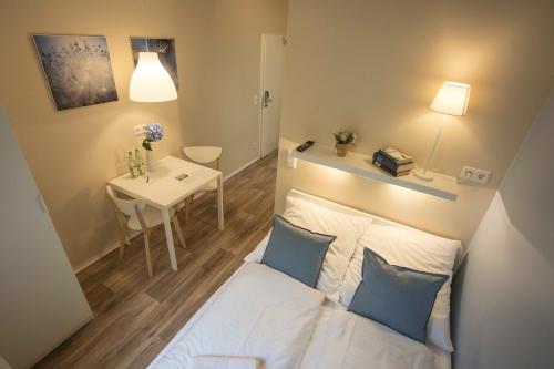 a small room with a bed and a table at GuestHouse Köhn51, zentral gelegene, stilvoll eingerichtete Zimmer mit eigener Teeküche in Nürnberg