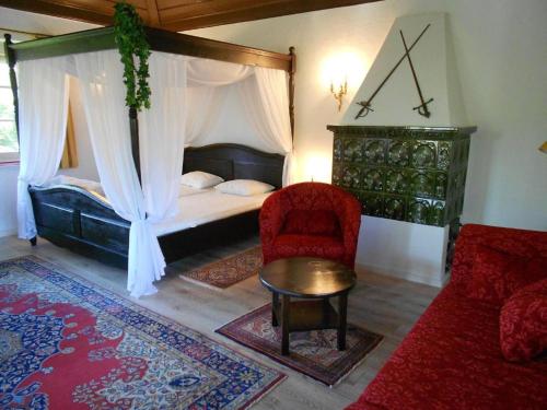 a bedroom with a canopy bed and a red chair at Königliche Villa - Turmappartement in Berchtesgaden