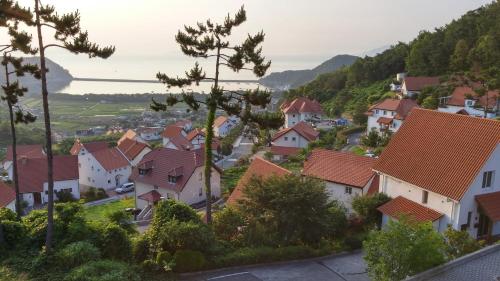 a village on a hill with houses and trees at Namhae Neuhaus in Namhae