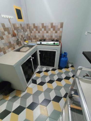 cocina con fregadero y suelo a cuadros en DJCI Apartelle with kitchen n bath 105-104, en Cabanatúan