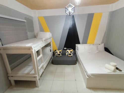 DJCI Apartelle with kitchen n bath 105-104 في كاباناتوان: غرفة صغيرة مع سريرين بطابقين وطاولة