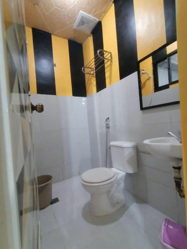 DJCI Apartelle with kitchen n bath 105-104 في كاباناتوان: حمام به مرحاض أبيض ومغسلة