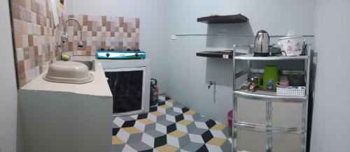 a small kitchen with a checkered floor at DJCI Apartelle with kitchen n bath 105-104 in Cabanatuan