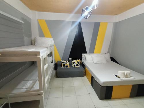 DJCI Apartelle with kitchen n bath 105-104 في كاباناتوان: غرفة صغيرة بها سريرين بطابقين