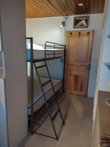Ce lit superposé se trouve dans un dortoir doté d'une porte. dans l'établissement résidence Le Platé, aux Carroz d'Arâches