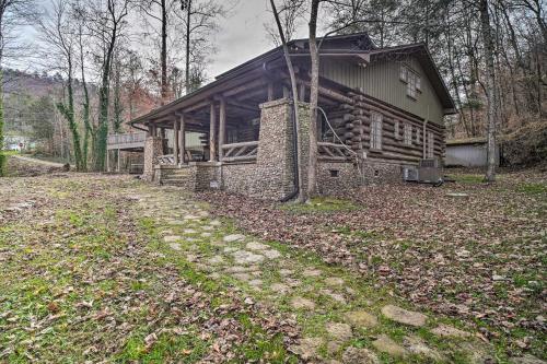 a log cabin in the middle of a forest at Tranquil Smoky Mountain Cabin with Porch and Fire Pit in Newport