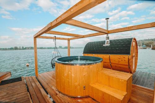 a hot tub on the deck of a boat at Costa del Kryspi Całoroczne Domy na Wodzie in Cholerzyn