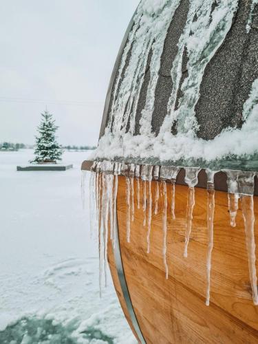 a boat with icicles hanging from it in the water at Costa del Kryspi Całoroczne Domy na Wodzie in Cholerzyn