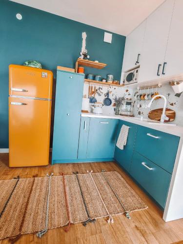 a kitchen with an orange refrigerator and blue cabinets at Costa del Kryspi Całoroczne Domy na Wodzie in Cholerzyn