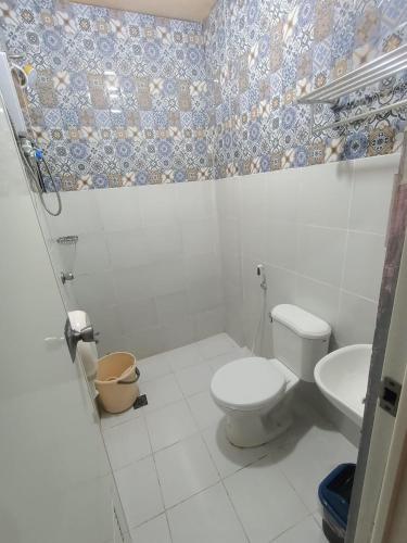 y baño con aseo y lavamanos. en Djci Apartelle with kitchen n bath 211-209 en Cabanatuan