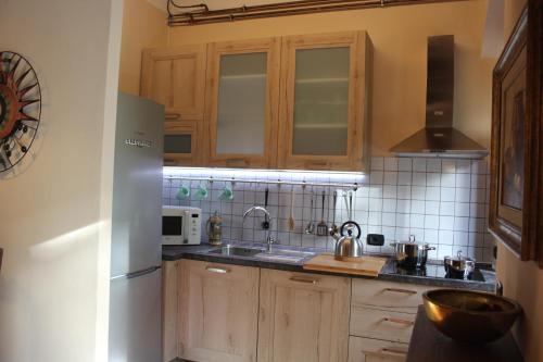 a kitchen with wooden cabinets and a white refrigerator at Holiday Home Villa il Cesto in Greve in Chianti