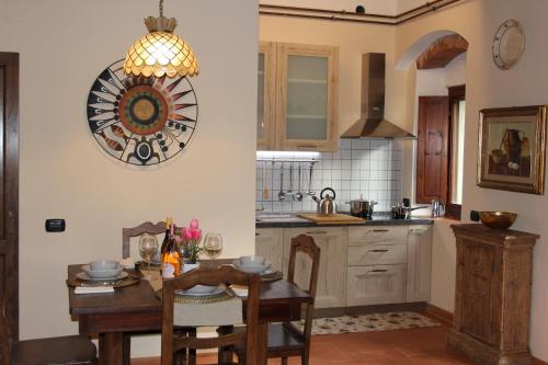 a kitchen with a table and a clock on the wall at Holiday Home Villa il Cesto in Greve in Chianti