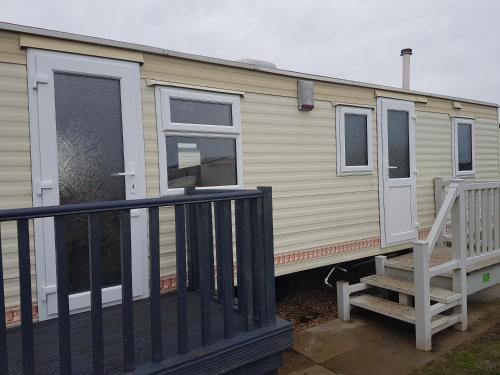 a mobile home with a porch and a staircase at The Chase Ingoldmells in Ingoldmells