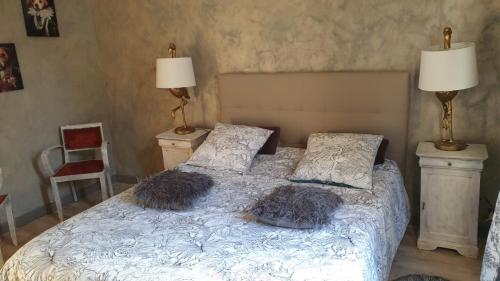 a bedroom with a bed with two pillows on it at la maison porte bonheur in Chantelle