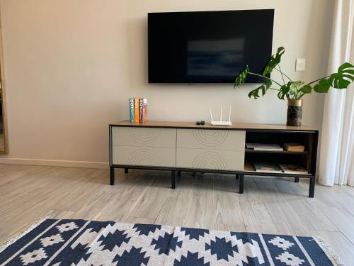 a living room with a tv on a wall at Umhlanga Arch 703 Sea View self-catering in Durban