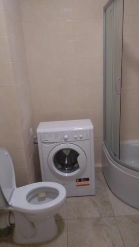 a bathroom with a washing machine and a toilet at Сихів Зелена Пасічна Новобудова ЖК Первоцвіт, Вулецька in Lviv