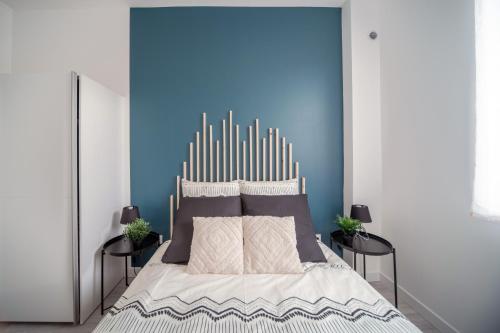 um quarto com uma cama grande e uma parede azul em Appartement Cosy Bressan em Bourg-en-Bresse