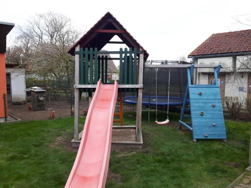 a playground with a slide and a play structure at Ruegen Fewo 108 1 in Zudar