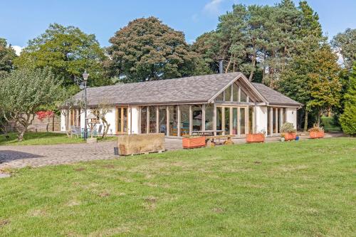 a large building with a grass field in front of it at Amber Lodge in Ashover