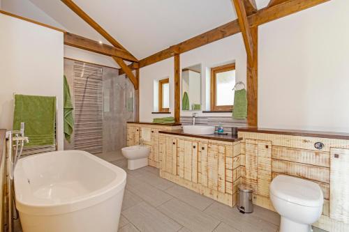 uma casa de banho com uma banheira, um WC e um lavatório. em Amber Lodge em Ashover