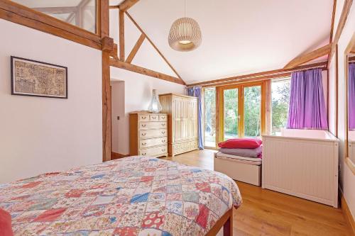 a bedroom with a bed and a dresser and windows at Amber Lodge in Ashover