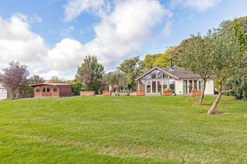 a large yard with a house in the background at Amber Lodge in Ashover