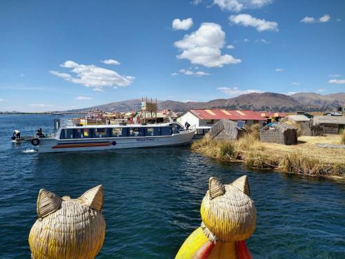 a boat in the water with two statues of cats at GHL Hotel Lago Titicaca in Puno