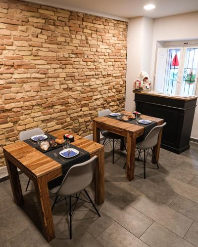 two tables and chairs in a room with a brick wall at B&B Civico 35 in Chieti