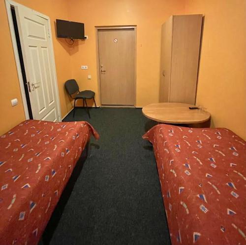 a hotel room with two beds and a table at Jeruzale Hotel in Vilnius