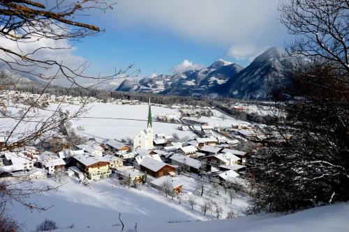 a village covered in snow with mountains in the background at Landhaus Alpenblick in Wiesing